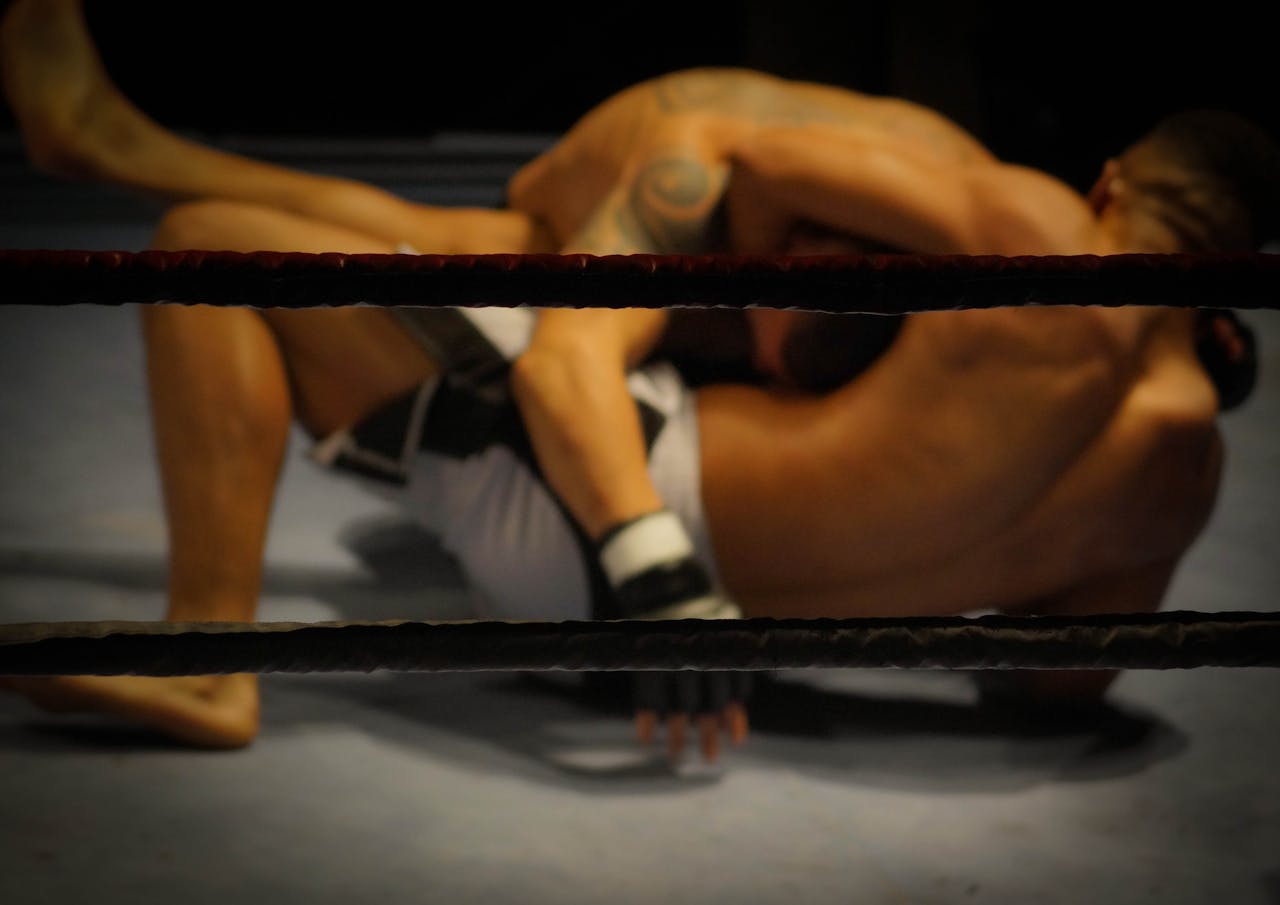Two athletes engaged in a dynamic wrestling match within the ring.